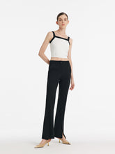 A lady wears mid-rise black pants.